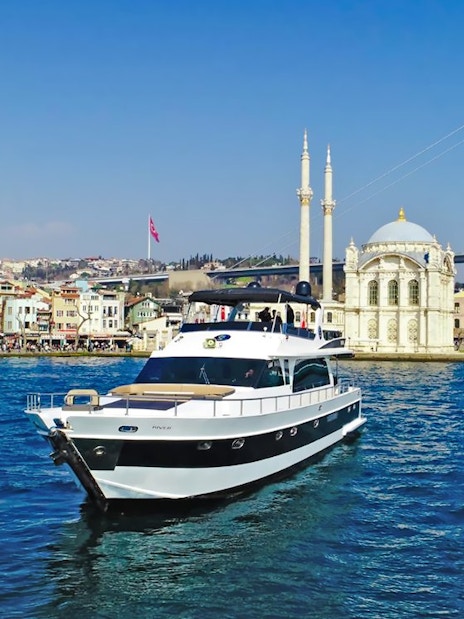 Luxury yacht cruising near Ortaköy Mosque on the Bosphorus, Istanbul.