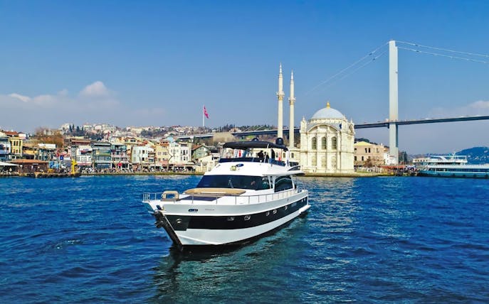 Luxury yacht cruising near Ortaköy Mosque on the Bosphorus, Istanbul.