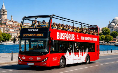 Open-top tour bus near Galata Tower and Bosphorus in Istanbul.