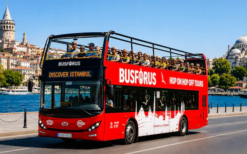 Open-top tour bus near Galata Tower and Bosphorus in Istanbul.