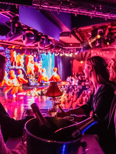 Tourists enjoying champagne at a Moulin Rouge show in Paris.