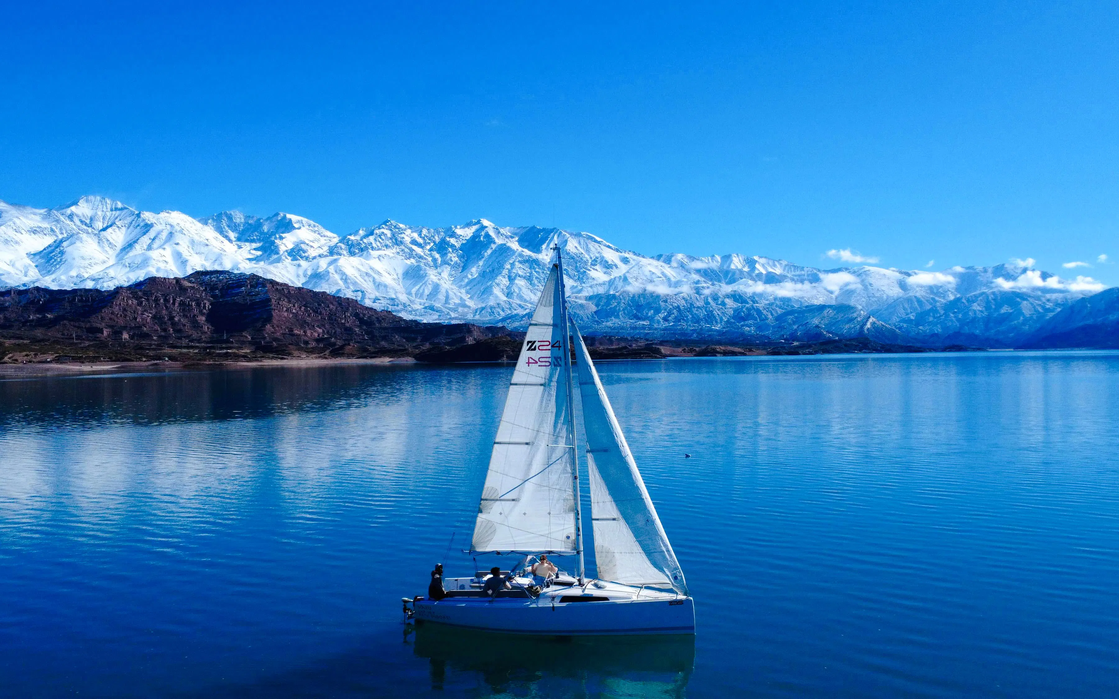 Sailboat on Potrerillos reservoir with Andes Mountains in the background.