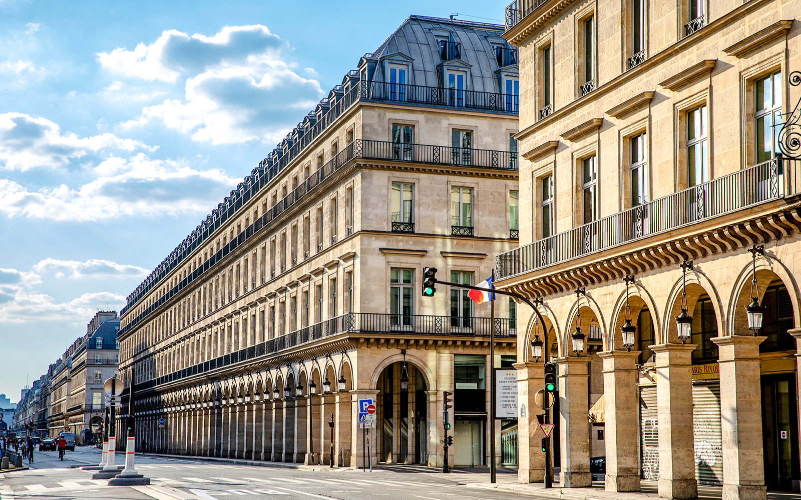 Rue de Rivoli street view with historic buildings and French flag in Paris.