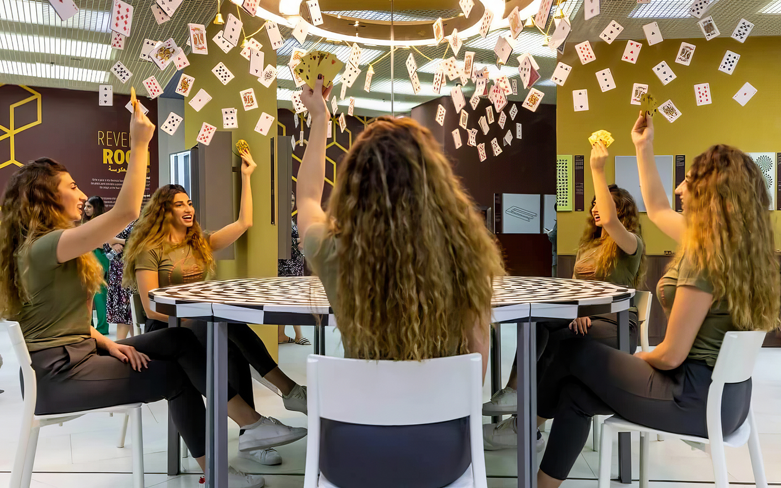Visitors experiencing optical illusions with mirrors and cards at Museum of Illusions Dubai.