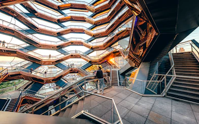 Vessel structure with visitors on staircases at sunset, New York City.