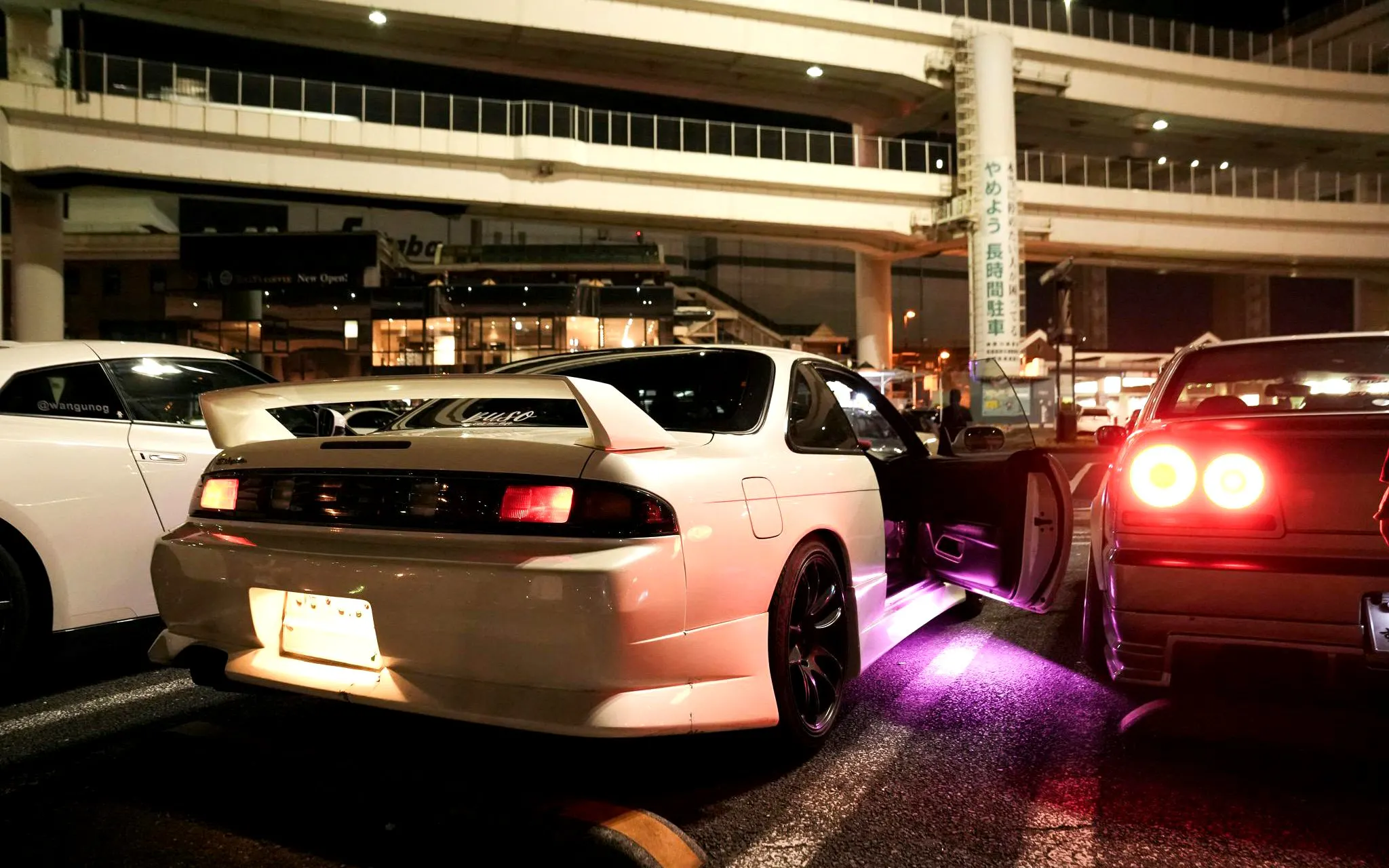 JDM cars parked at a Tokyo meetup during a night tour.