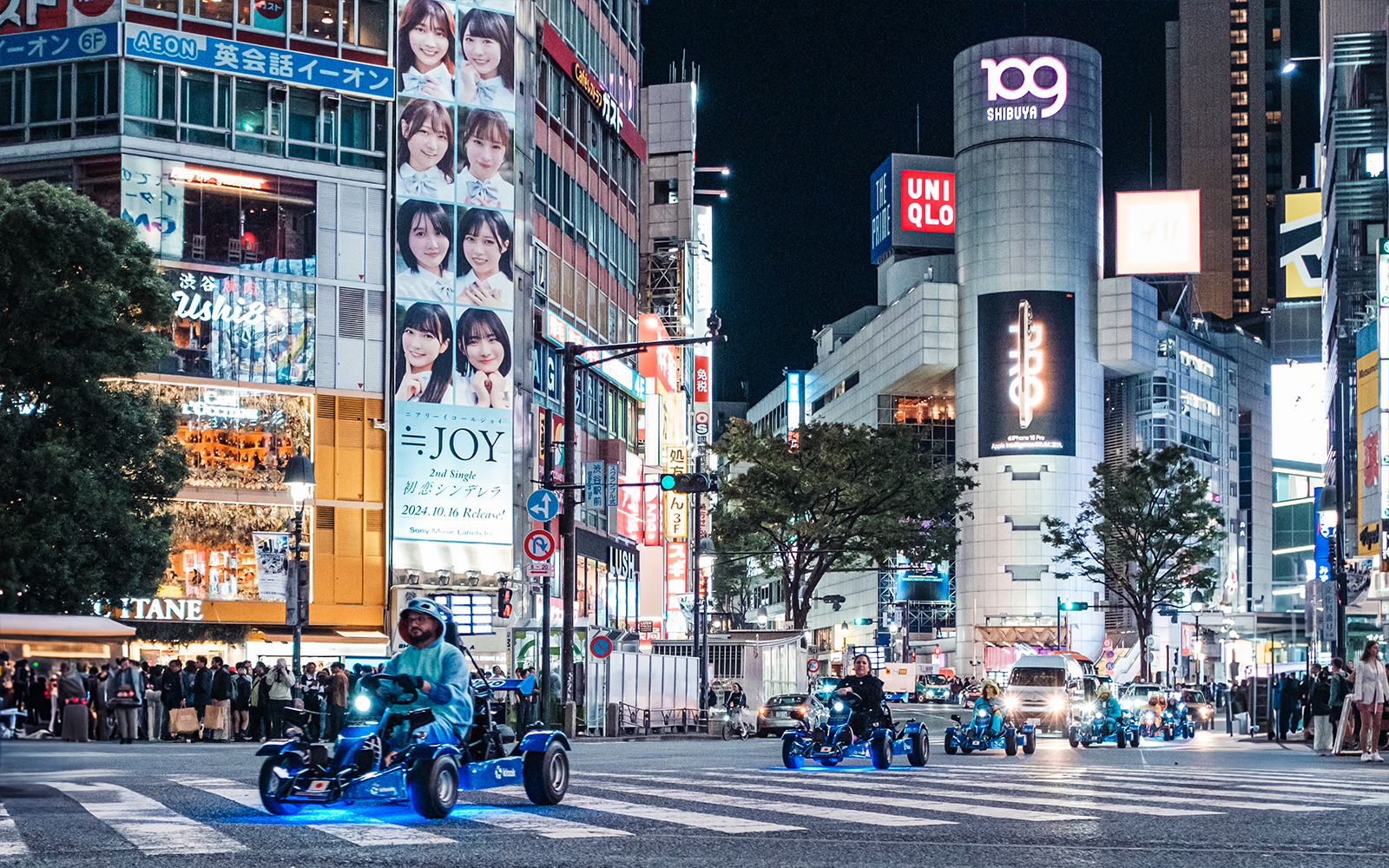People driving go-karts through Shibuya at night during Shinjuku tour.