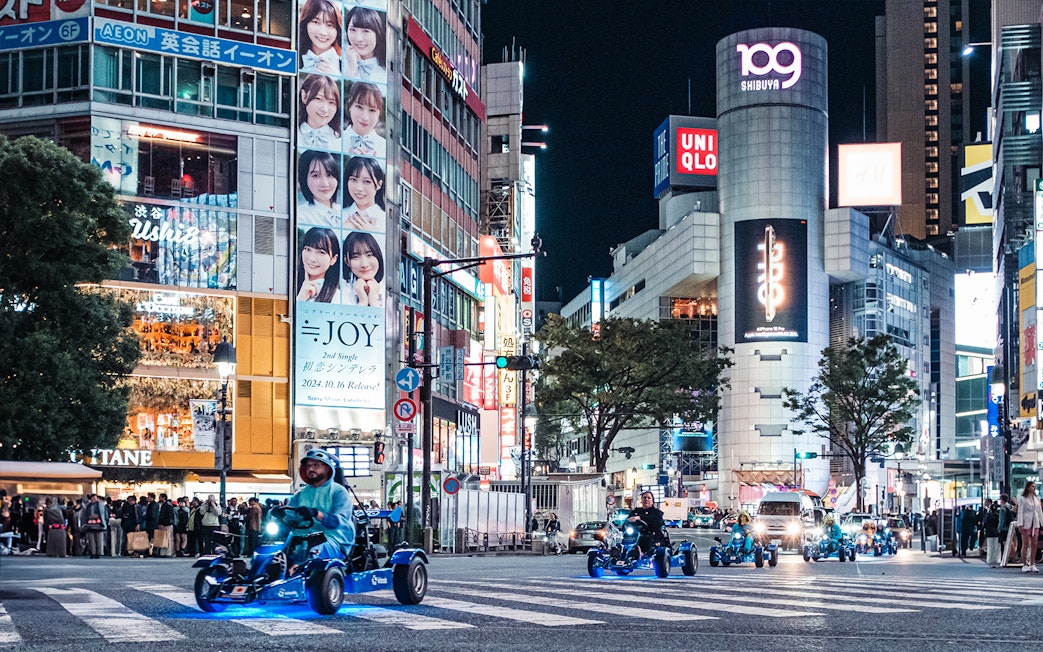People driving go-karts through Shibuya at night during Shinjuku tour.