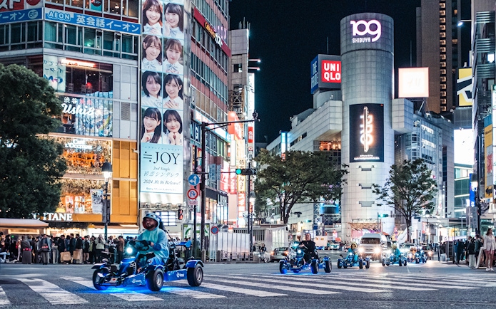 People driving go-karts through Shibuya at night during Shinjuku tour.