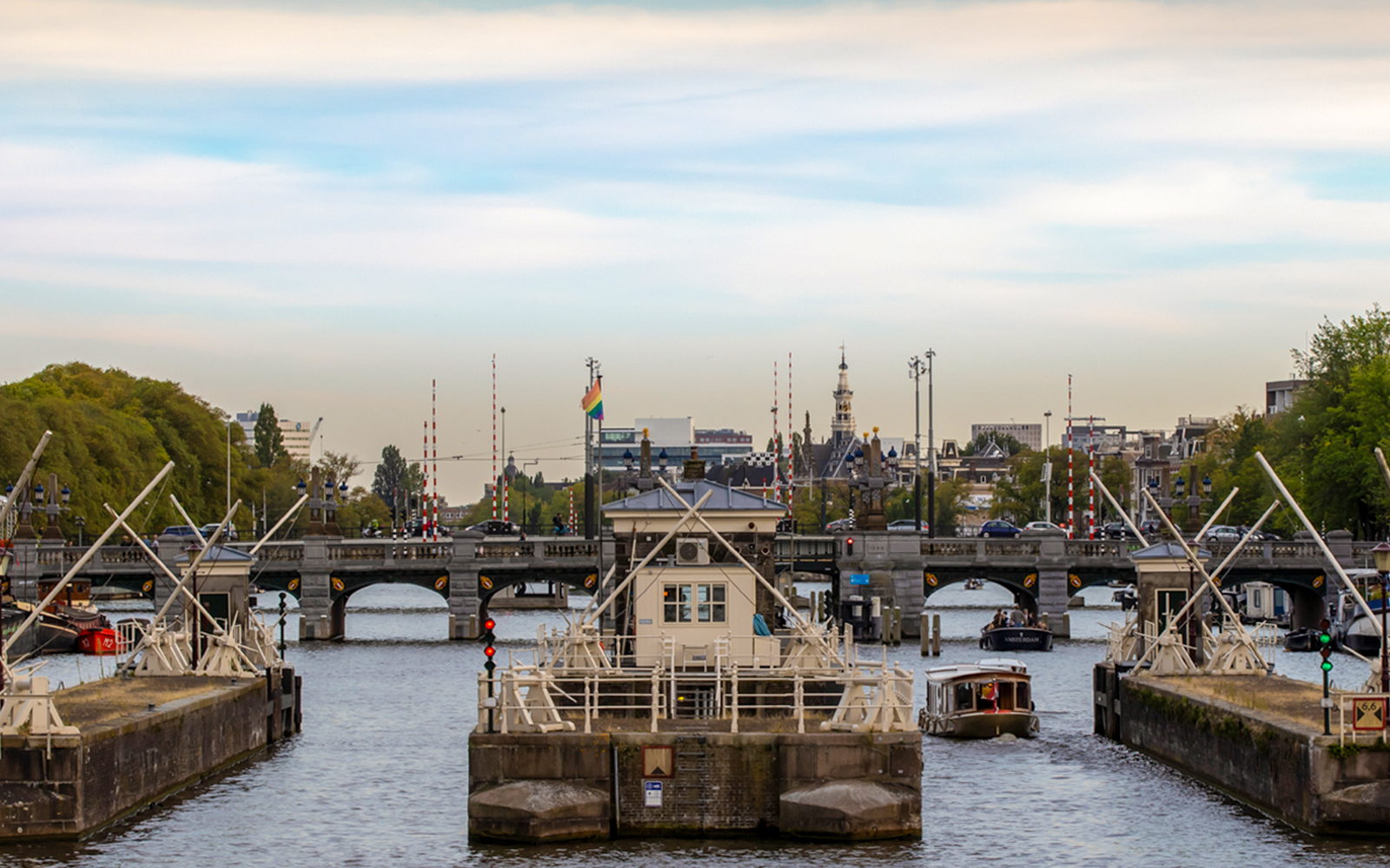 Amsterdam canal with boats and bridge, view from a canal cruise.