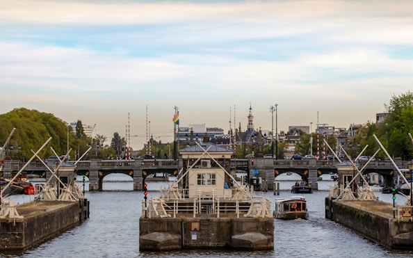Amsterdam canal with boats and bridge, view from a canal cruise.