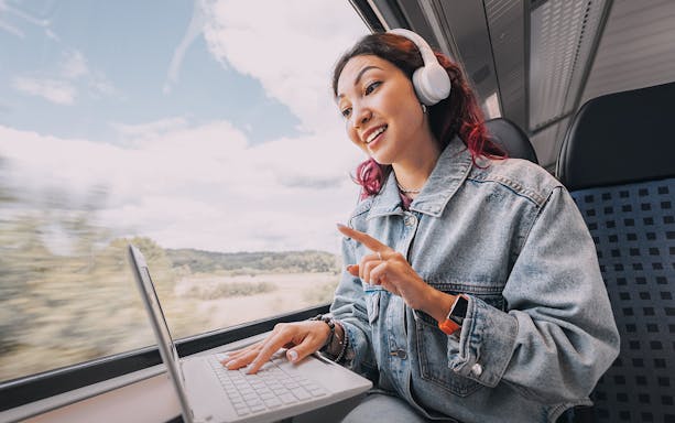 Person using laptop with internet on a train.