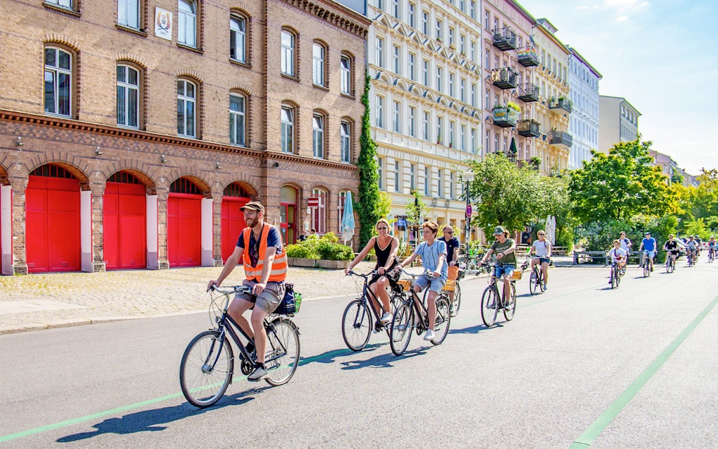 Cyclists on a guided tour ride past historic buildings in Berlin.