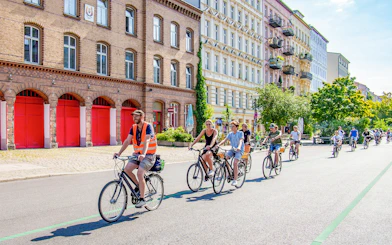 Cyclists on a guided tour ride past historic buildings in Berlin.