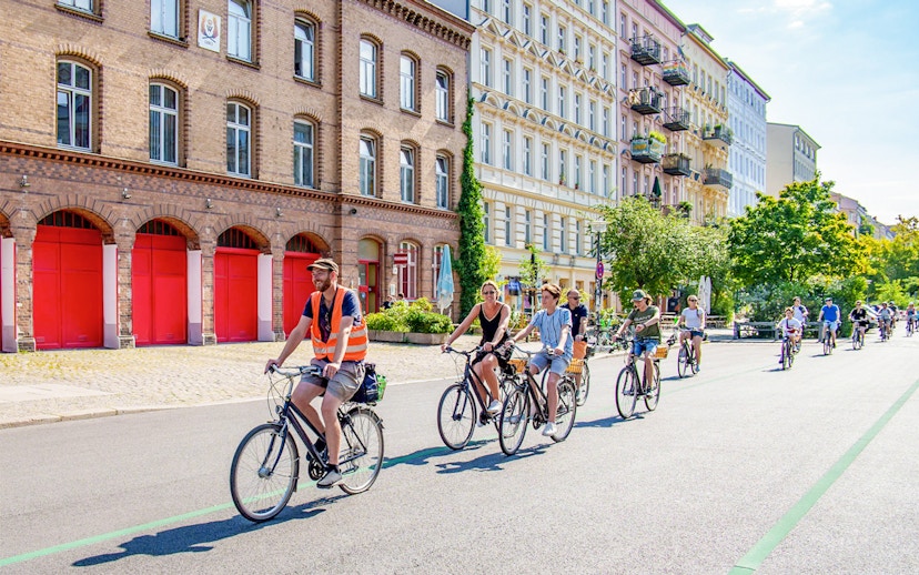 Cyclists on a guided tour ride past historic buildings in Berlin.