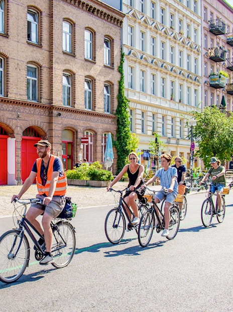 Cyclists on a guided tour ride past historic buildings in Berlin.