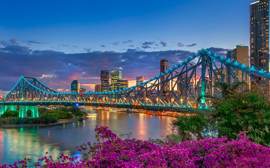 Brisbane Story Bridge at twilight with city skyline in the background.