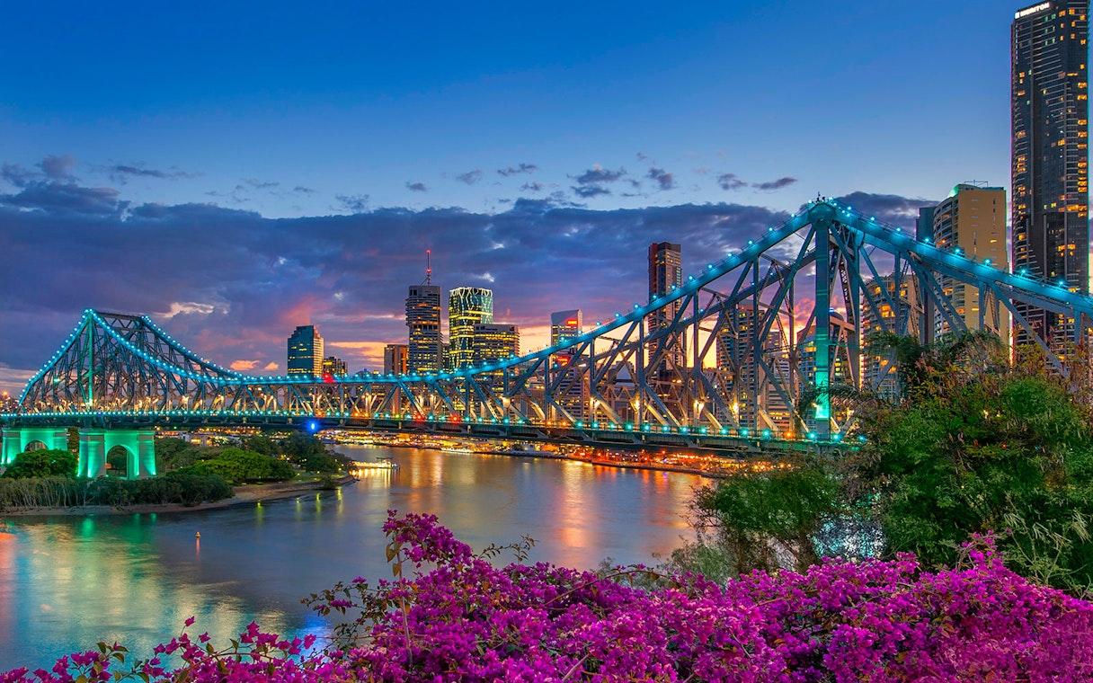 Brisbane Story Bridge at twilight with city skyline in the background.