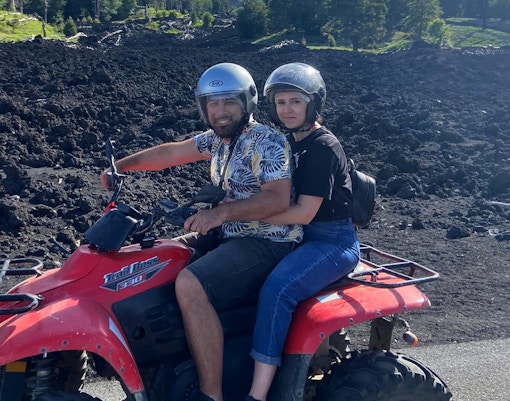 Quad bikes traversing rocky terrain at Alcantara Gorges, Sicily, with Mount Etna in the background.