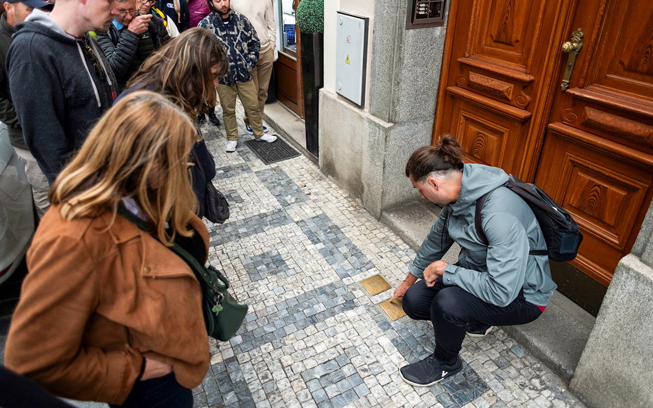 Guests observing Stolpersteine in Prague's Jewish Quarters.