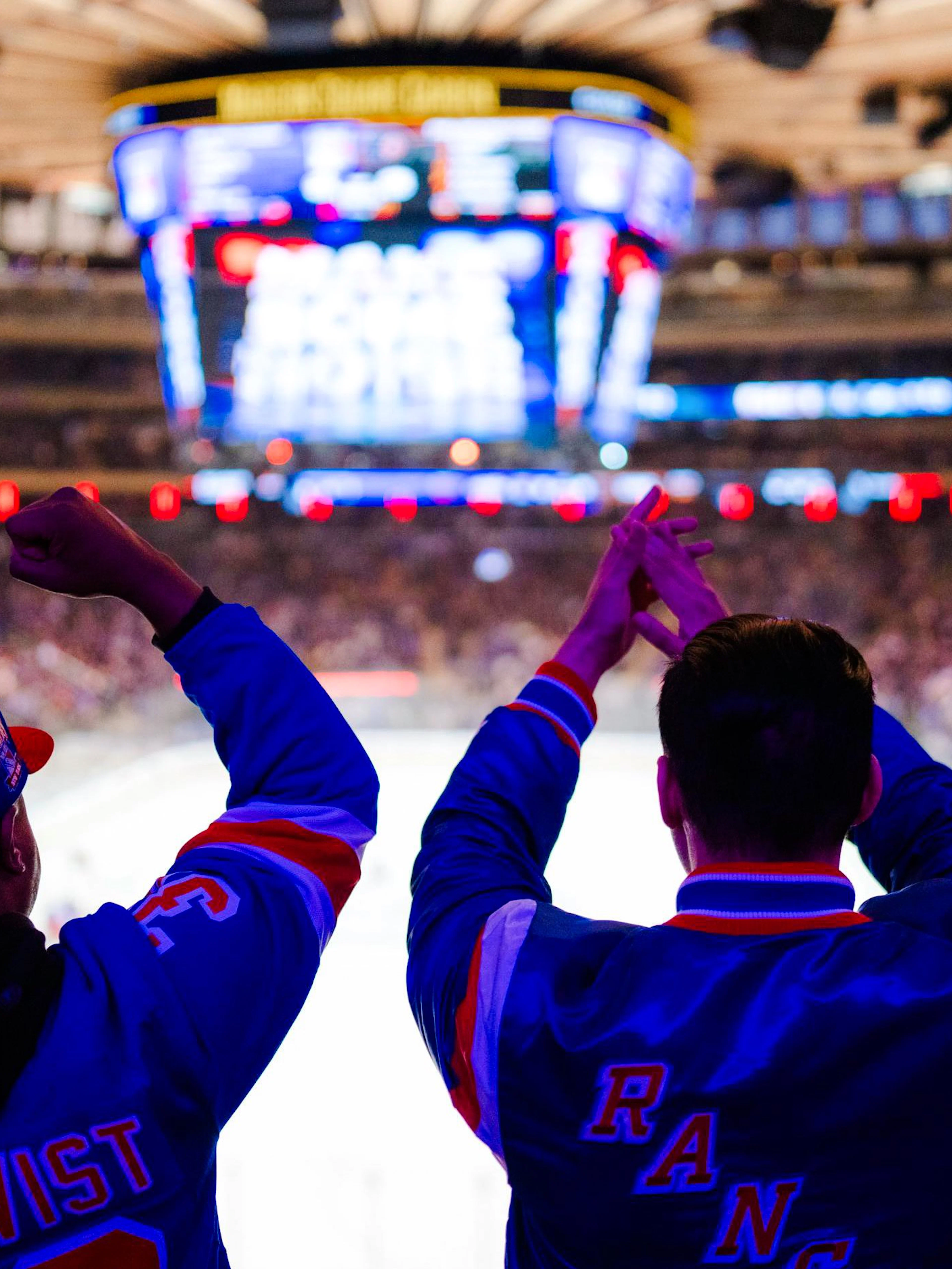 Fans cheering at a New York Rangers game in Madison Square Garden.