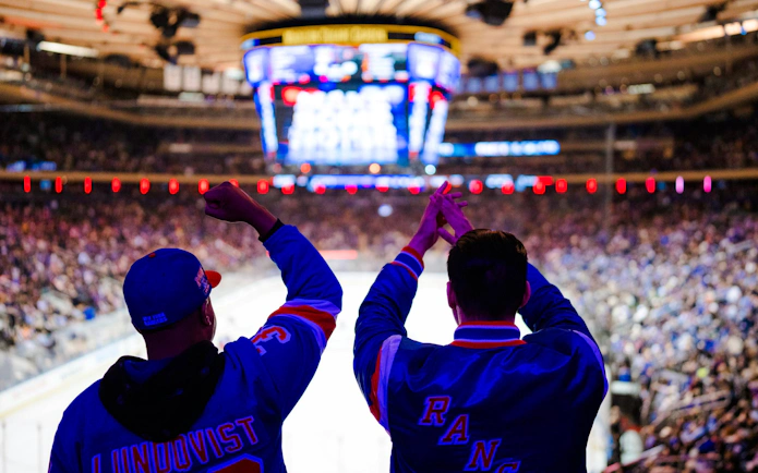 Fans cheering at a New York Rangers game in Madison Square Garden.