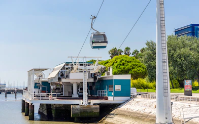 Telecabine Lisbon cable car station by the waterfront with gondola in the air.