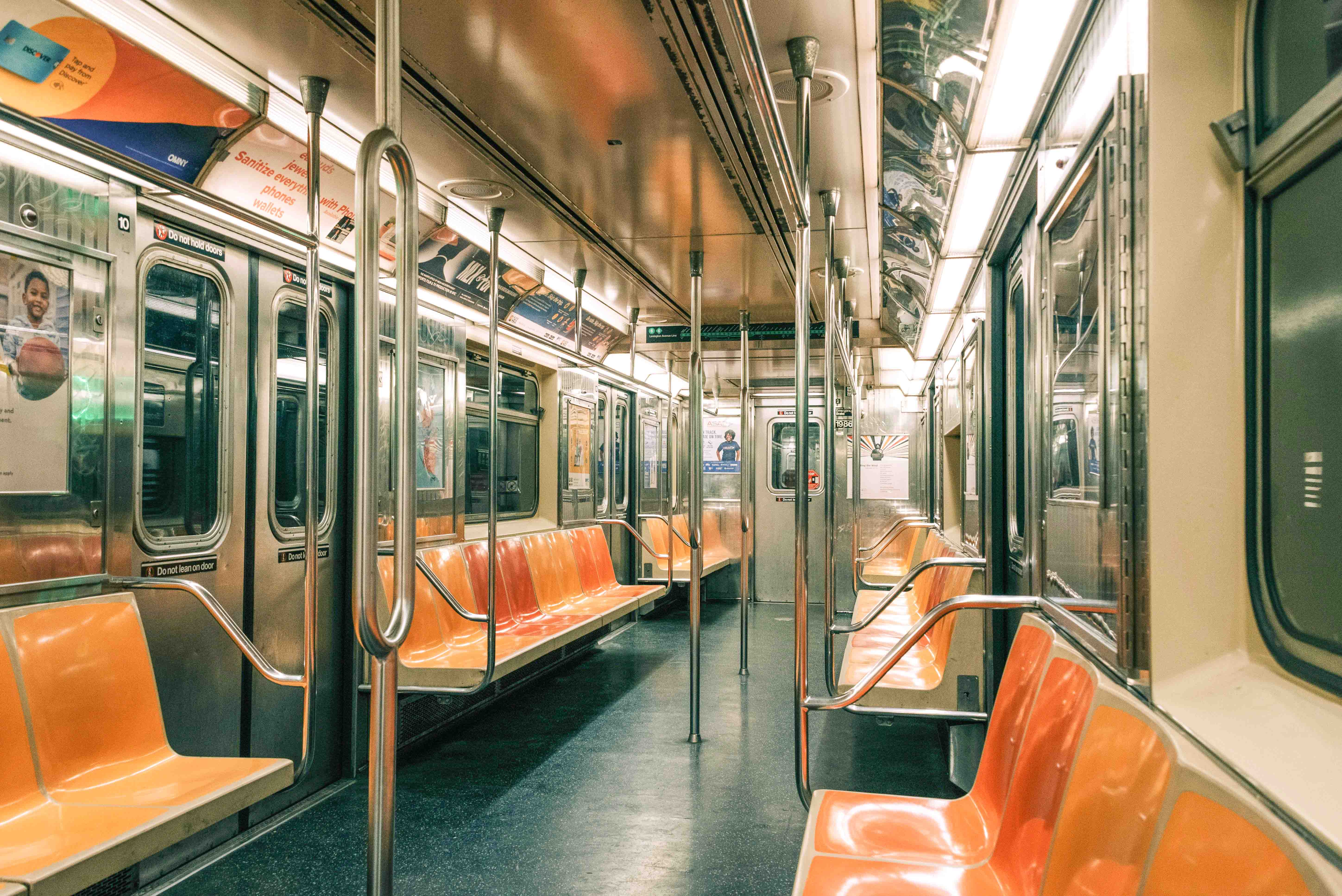 New York City subway train arriving at a bustling underground station.