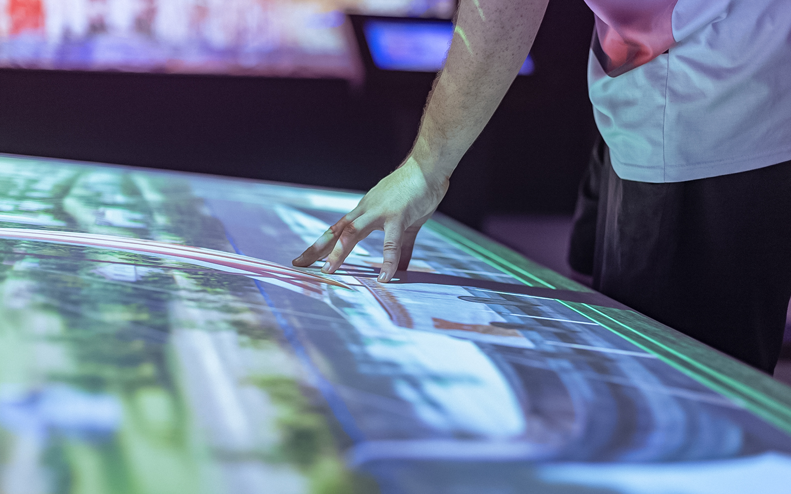 Interactive display showing Montserrat Monastery tour details with hand pointing.