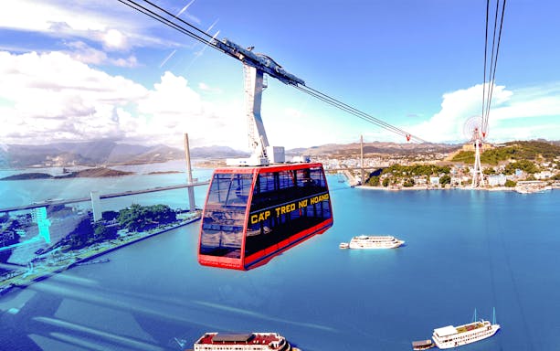 Cable car over Halong Bay with view of Bai Chay Bridge and Sun Wheel in Vietnam.