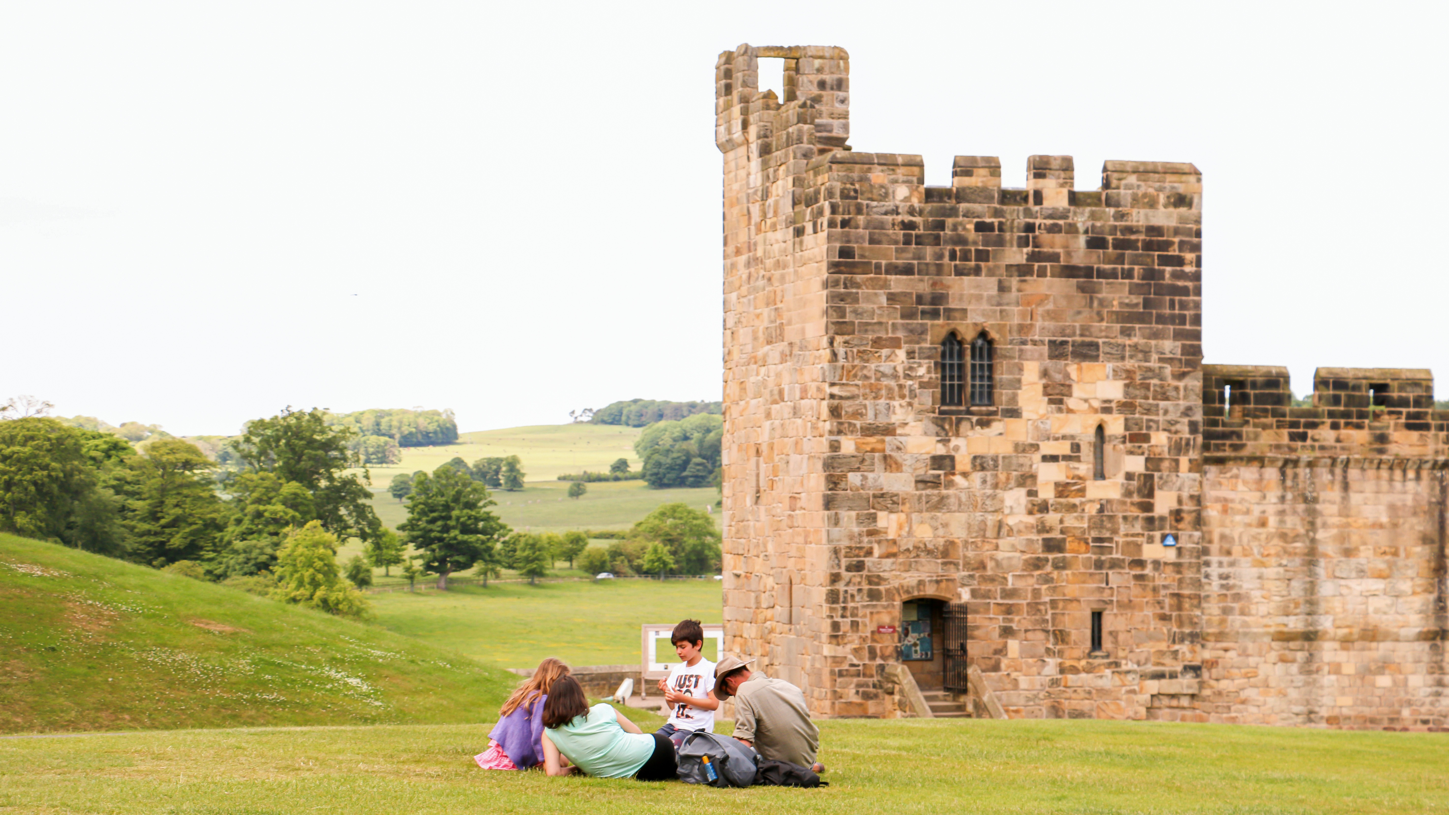 Family sitting in front of Alnwick Castle