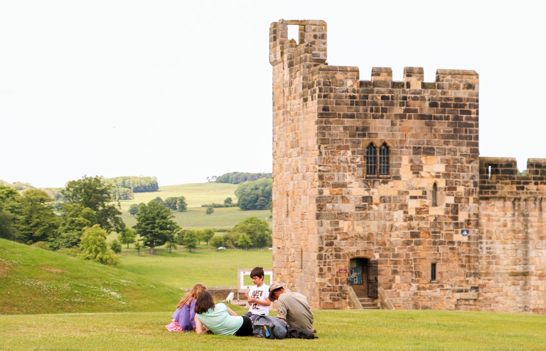 Family sitting in front of Alnwick Castle