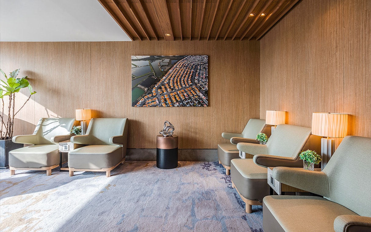 Seating area in Plaza Premium Lounge with modern chairs and wall art.