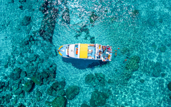 Aerial view of a boat cruising in the clear waters of the Blue Lagoon near Latchi, Cyprus.