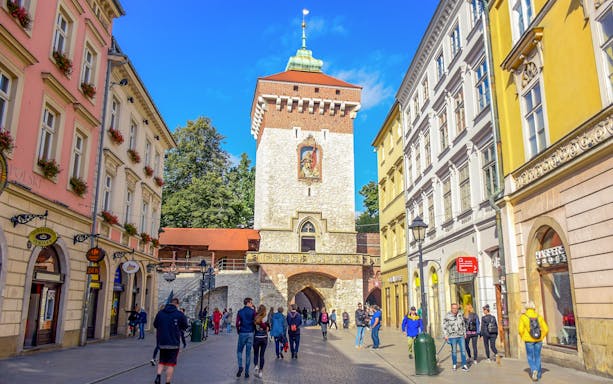 Krakow Old Town walking tour with view of St. Florian's Gate and bustling street.