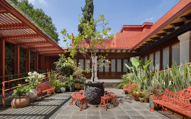 Courtyard with red benches and plants at Museo Casa Kahlo, Mexico City.