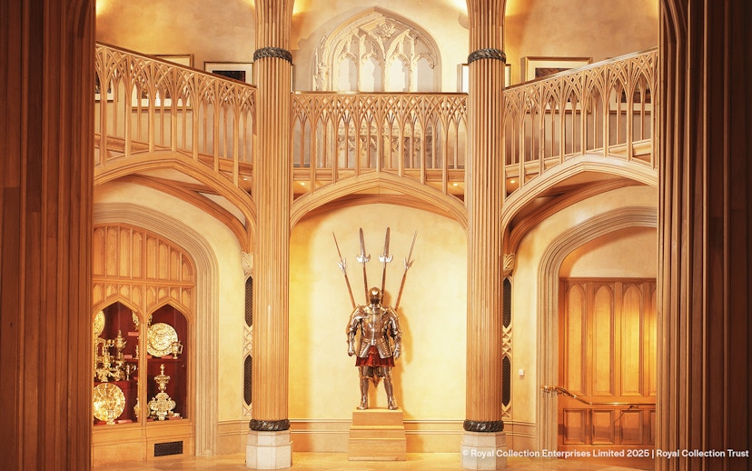 Windsor Castle interior with ornate wooden columns and medieval armor display.