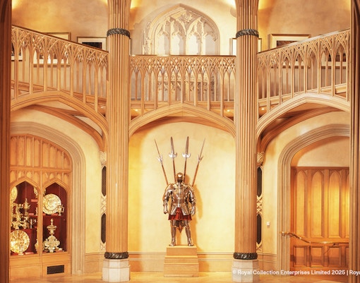 Windsor Castle interior with ornate wooden columns and medieval armor display.