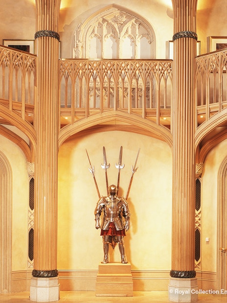 Windsor Castle interior with ornate wooden columns and medieval armor display.
