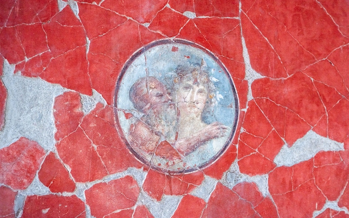 Herculaneum fresco depicting two figures on a red background.