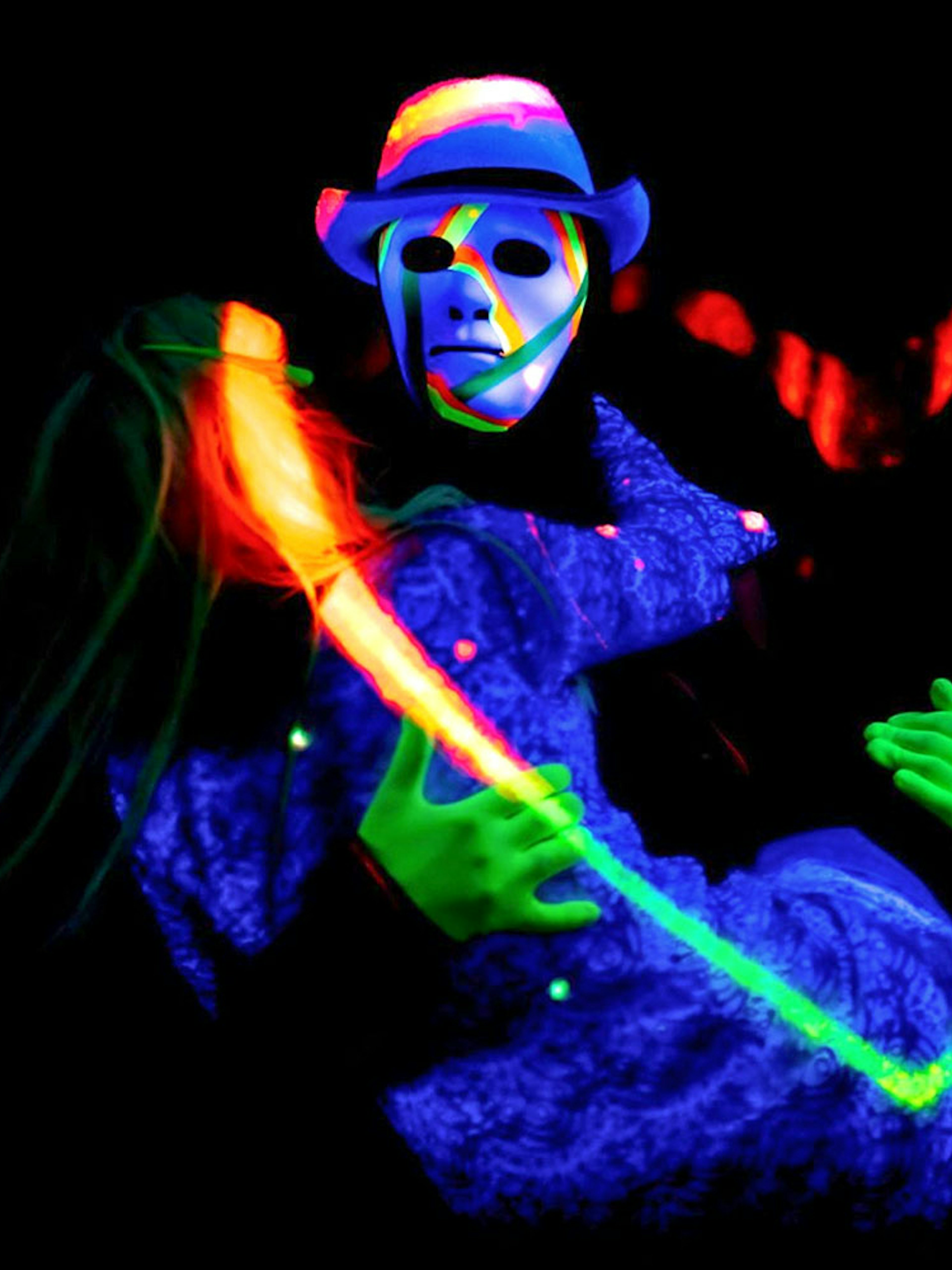 Performers in neon costumes at black light theatre, Prague.