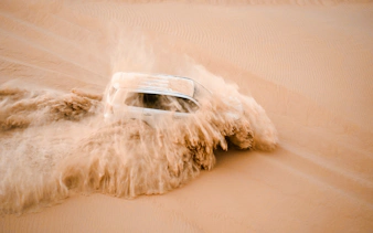 SUV driving through sand dunes during Abu Dhabi evening desert safari.
