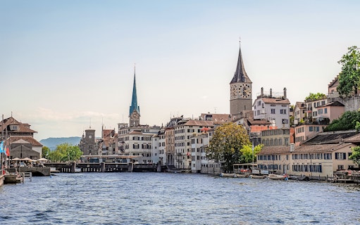 Zurich cityscape with historic buildings and church towers along the Limmat River.