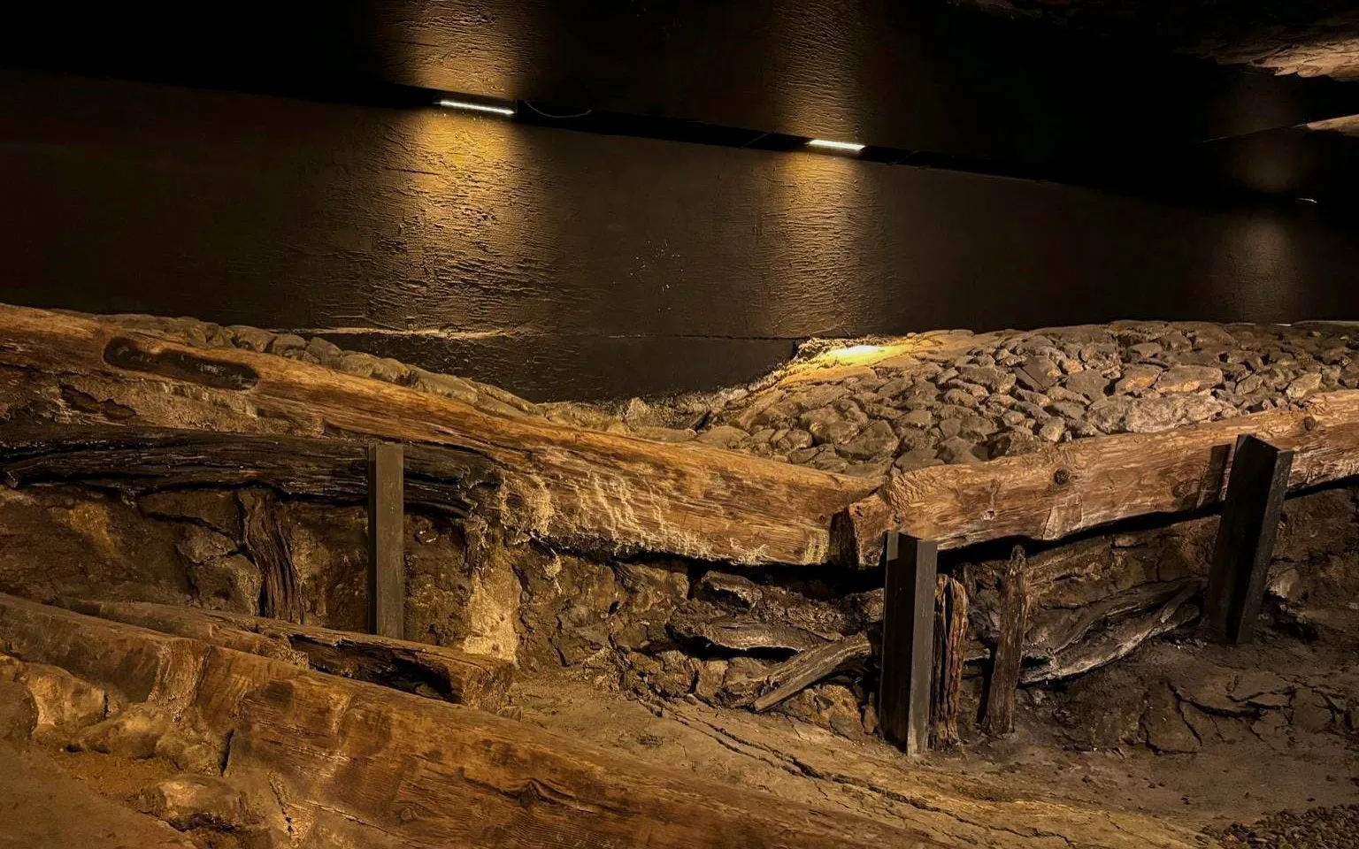 Ancient wooden structures and stone pathway at Rynek Underground Museum, Krakow.