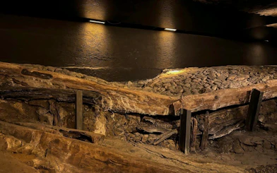 Ancient wooden structures and stone pathway at Rynek Underground Museum, Krakow.