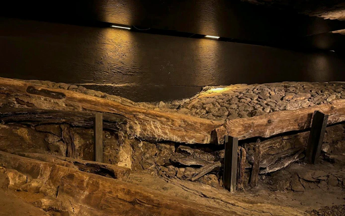 Ancient wooden structures and stone pathway at Rynek Underground Museum, Krakow.
