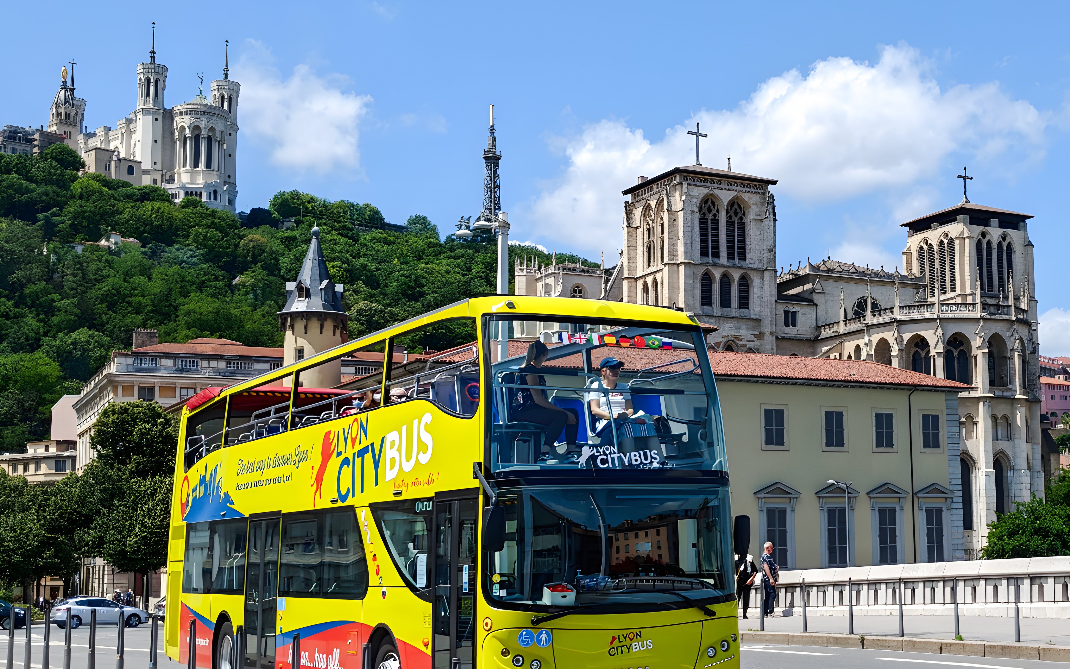 Lyon city tour bus passing by Basilica of Notre-Dame de Fourvière, France.