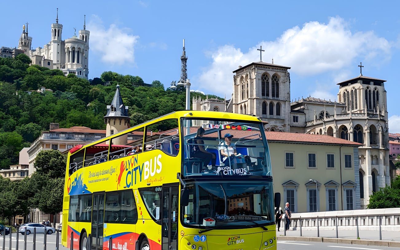 Lyon city tour bus passing by Basilica of Notre-Dame de Fourvière, France.
