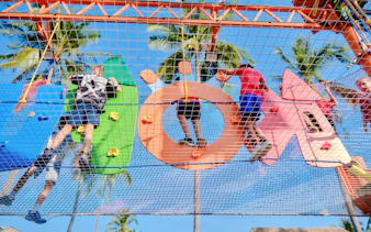 Children climbing colorful obstacle course at outdoor adventure park in Phuket.