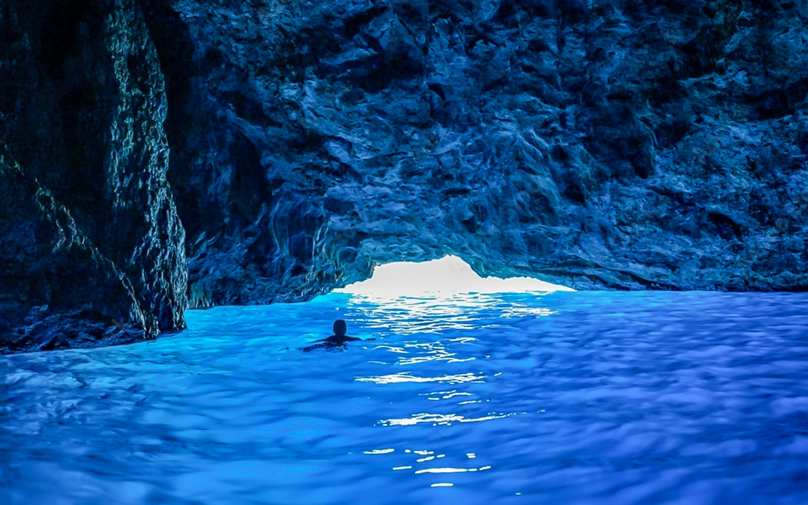 Swimming in the vibrant waters of a blue cave.